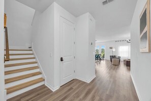 Ein modernes Interieur mit Treppe, Essbereich und Wohnraum mit Aussicht.