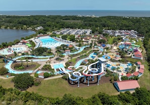 An aerial view of a water park with multiple slides and pools, surrounded by parking and greenery. - Coastal Sage by Redfern (St. Simons Island)