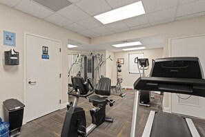 A fitness center with cardio machines, free weights, and a mirrored wall. - Surf Dweller 207🌊Gulf Front🏖️2 Free Beach Setups (Fort Walton Beach)