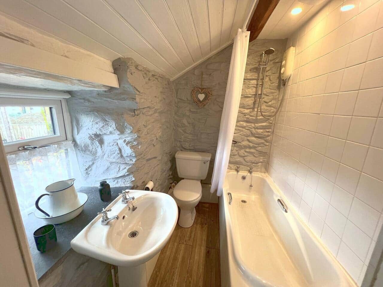 Un baño con lavamanos, inodoro y bañera.