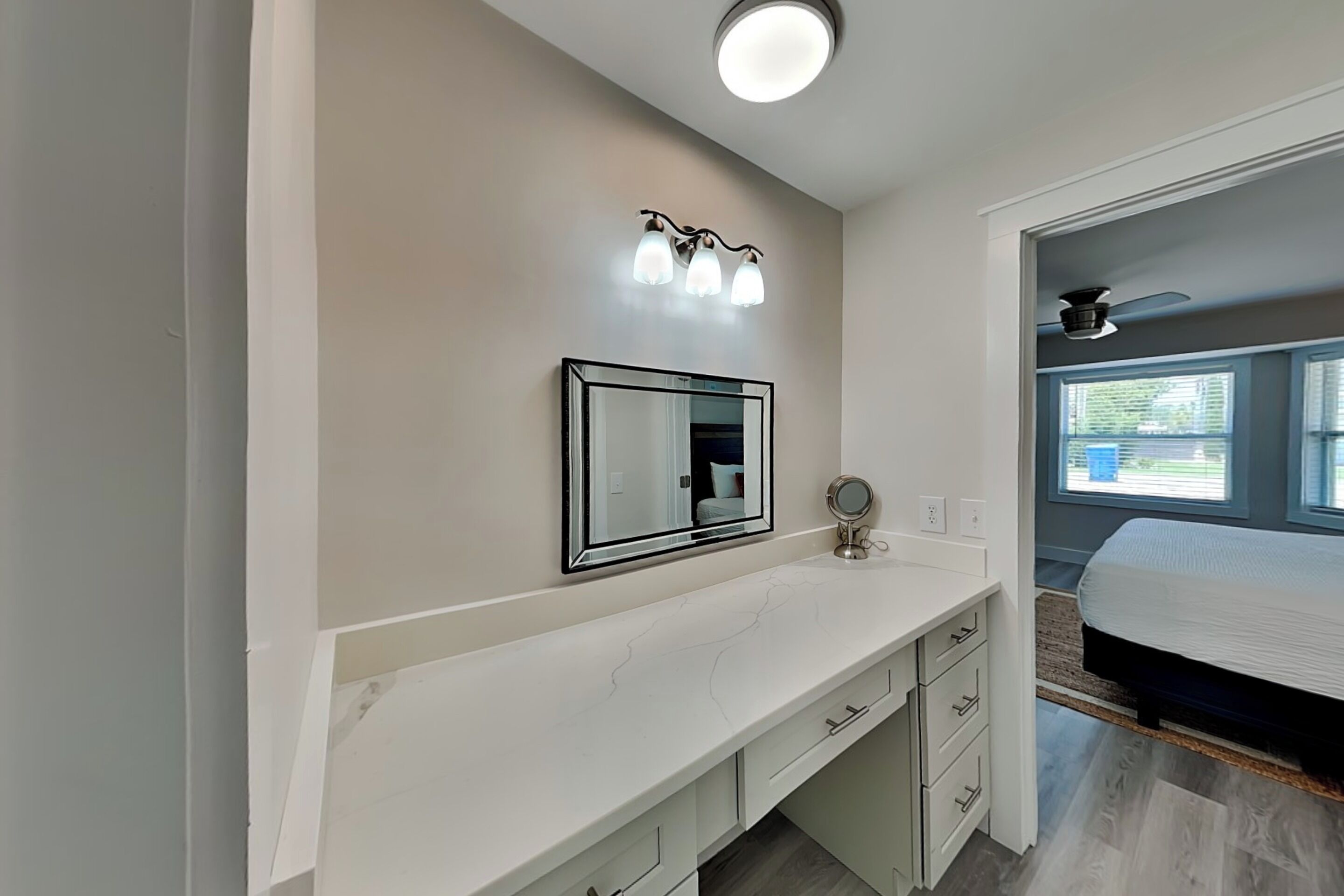 Une salle de bain moderne avec un meuble-lavabo, un miroir et un luminaire au plafond.