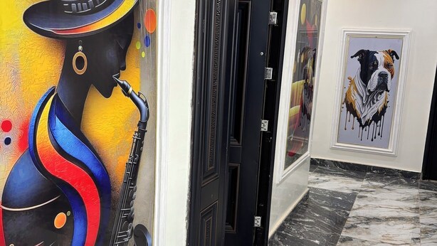 A hallway with a 'CONFERENCE ROOM' sign, a framed artwork of a dog, and a large abstract painting on the wall.