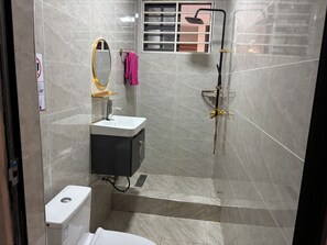A bathroom with a toilet, sink, and shower area. - KELNESSA HOTEL (Obuasi)