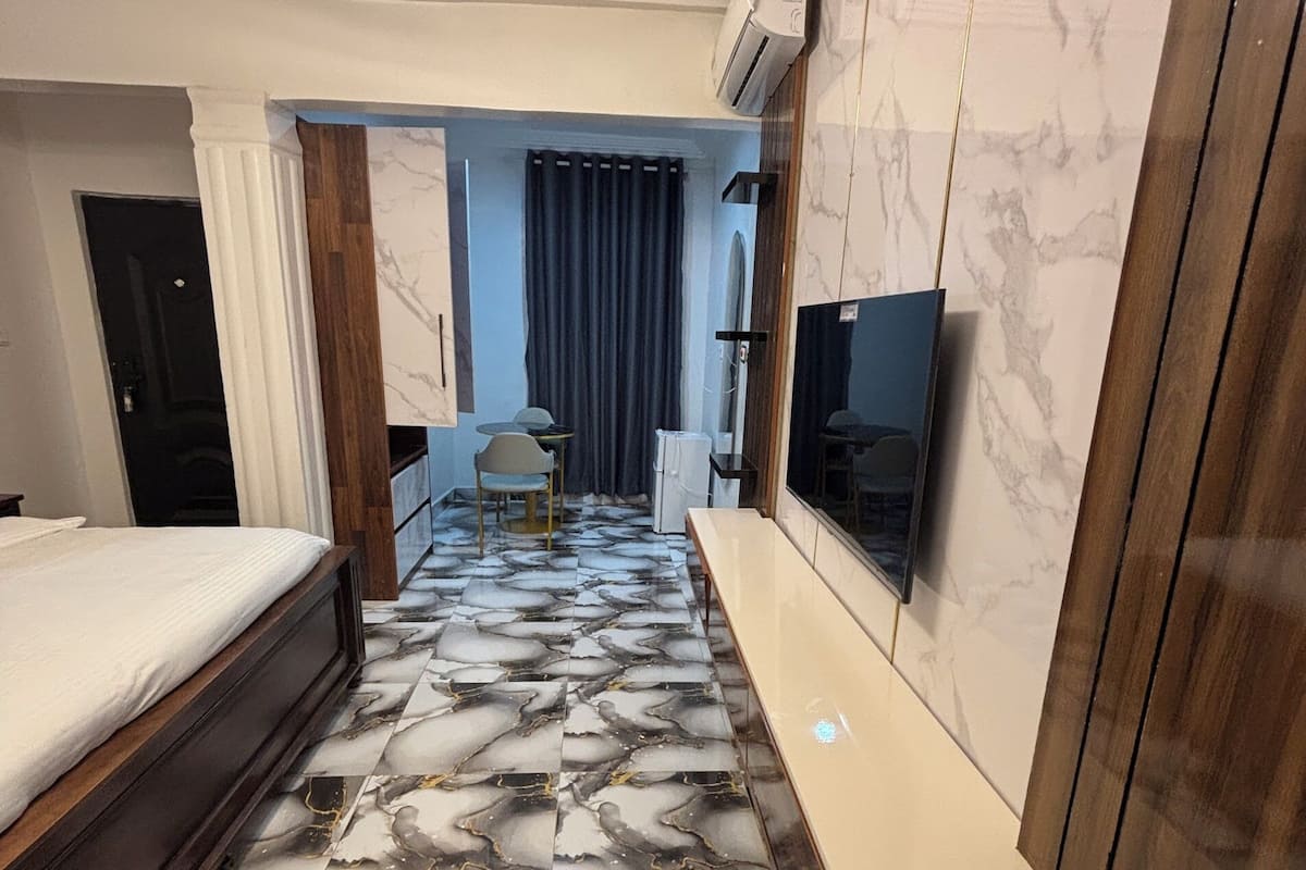 Una habitación de hotel con cama, televisión, escritorio y baño.