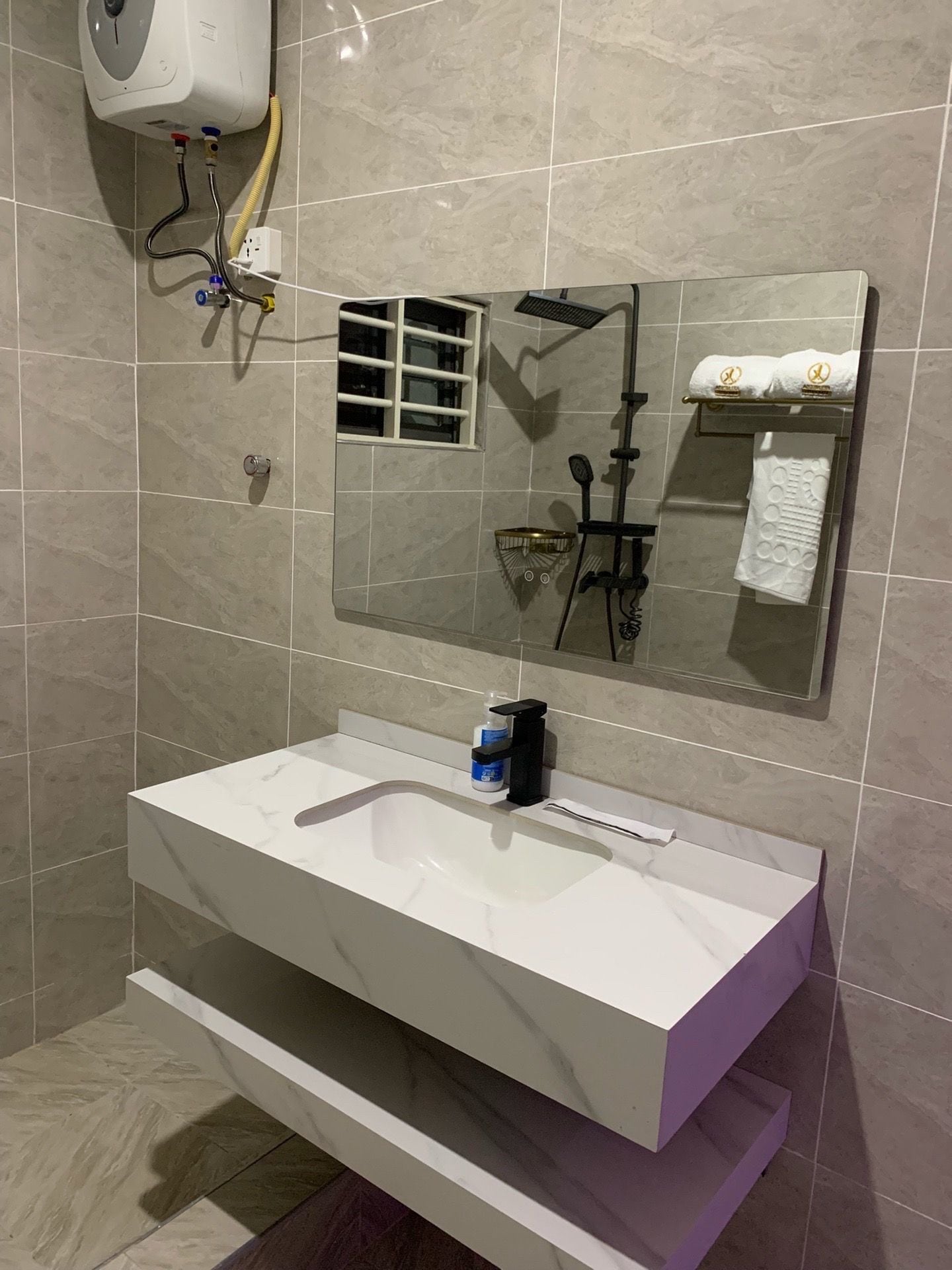 A bathroom with a white sink, a mirror, and a towel rack.