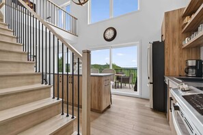 Eine moderne Küche mit einer Holzinsel, einem Essbereich und einer Treppe, die zu einer oberen Ebene führt.