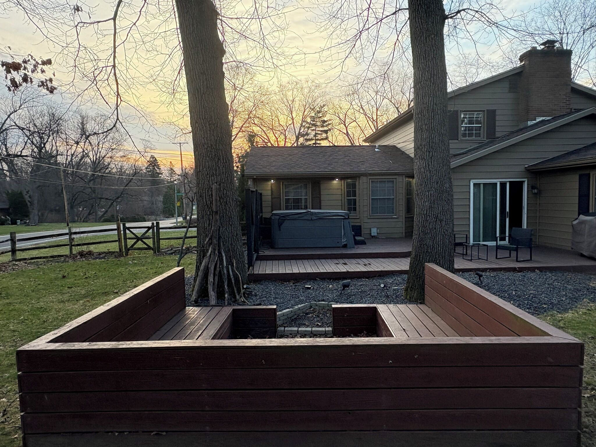 A house with a deck, a hot tub, and a covered patio area.