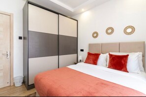 Ein Schlafzimmer mit Bett, Kleiderschrank, Nachttisch und Wanddekorationen.