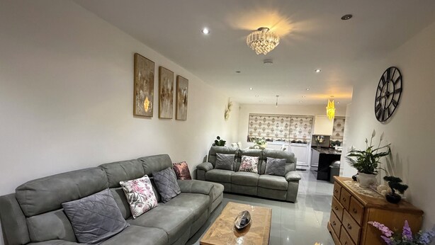 A living room with a grey sofa, a coffee table, and a wooden cabinet with plants. - Greenview Manor
Ideal location for family in north London (London)