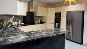 A modern kitchen with a marble countertop, stainless steel appliances, and a decorative star-shaped light fixture. - Greenview Manor
Ideal location for family in north London (London)