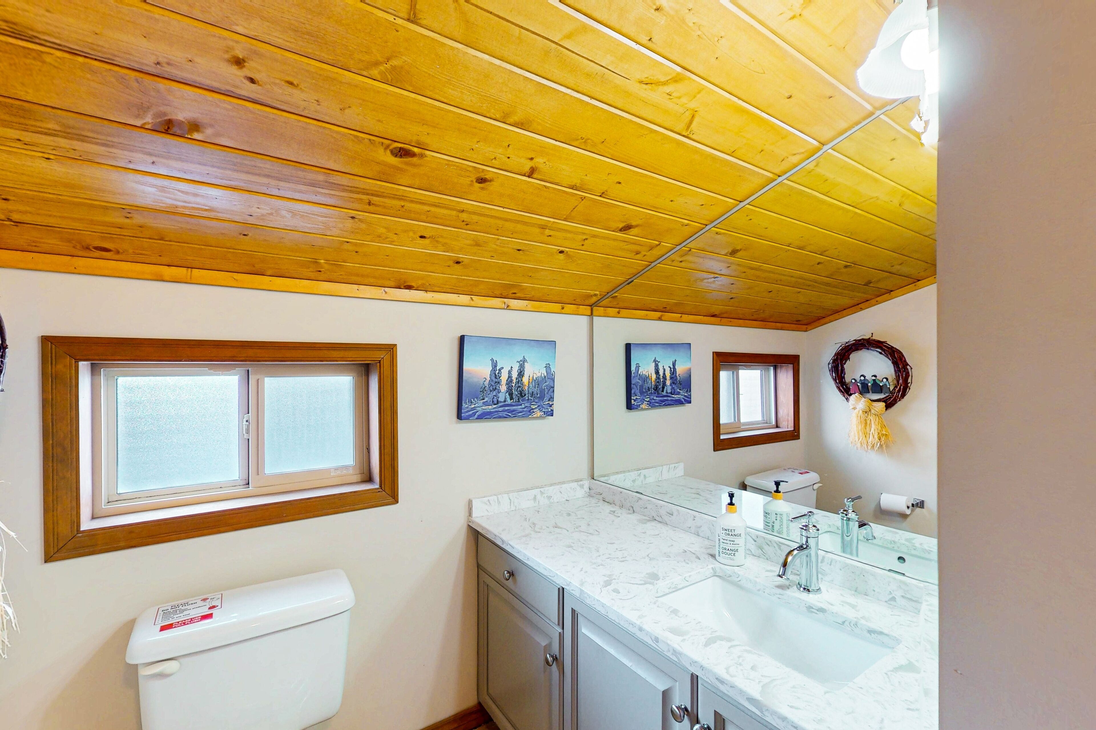 Une salle de bain avec des toilettes, un lavabo et une fenêtre.