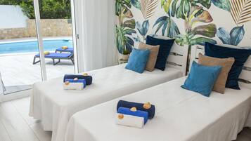 Una habitación con dos camas, piscina y decoración temática tropical.