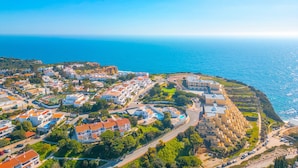 Eine Vogelperspektive einer Küstenstadt mit Häusern, Straßen und freiem Blick auf das Meer.