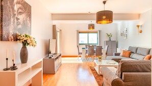 Un salon moderne comprenant un canapé, une table basse et un coin repas avec des chaises et une table.