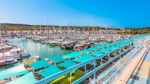 Un puerto deportivo con numerosas embarcaciones amarradas, cielo despejado y vistas del paisaje circundante.