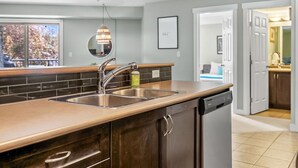 Una cocina moderna con un lavamanos doble, electrodomésticos de acero inoxidable y encimera de madera.