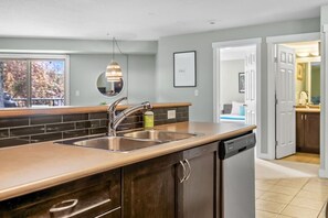 A modern kitchen with a double sink, stainless steel appliances, and a wooden countertop. - Laguna | Lake | Outdoor Pool/Hot Tub | Gym | Pets (Invermere)