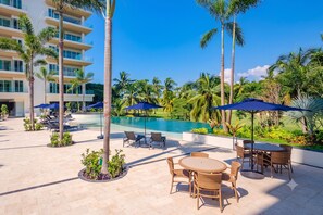 A resort pool area with lounge chairs, umbrellas, and a pool. - Luxury Vallarta Marina 1BR Balcony Golf  (Puerto Vallarta)