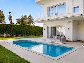 A modern two-story house with a swimming pool, a covered patio, and a view of the surrounding greenery. - Luxurious Villa Rental in Tunis With Private Indoor Pool (La Soukra)