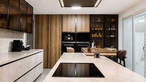 Una cocina moderna con una isla central, electrodomésticos integrados y armarios de madera.