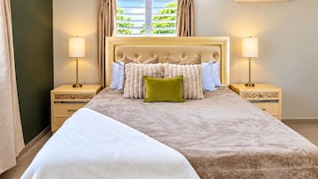 Habitación de hotel con una cama grande, dos mesitas de noche, una ventana con cortinas y un equipo de aire acondicionado en la pared.