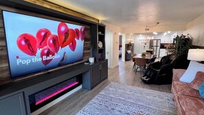 Un salon moderne avec un téléviseur à écran plat, un tapis à motifs et un canapé.
