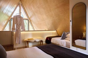 Un dormitorio con un espejo grande, una cama, una mesita de noche y una ventana.