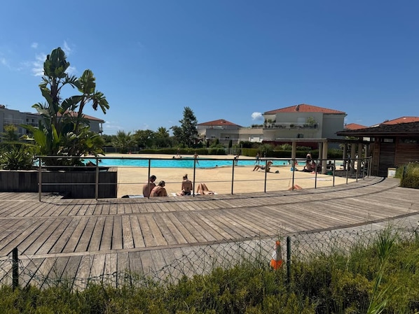 A wooden deck with a pool, surrounded by buildings with red roofs. - Charming apartment in amazing Antibes with sea view (Antibes)