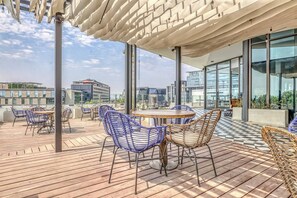 Una terrazza sul tetto con posti a sedere all'aperto, ampie finestre e vista sulla città.