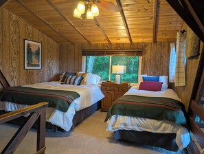 A cabin with two beds, a wooden ceiling, a window with a view of greenery, and a framed picture on the wall. - Aspen Peak Chalet | Lake Aspen, Foliage, Fire Pit (Innsbrook)