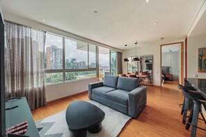 Ein modernes Wohnzimmer mit einer Couch, einem Couchtisch und einem Essbereich mit einer Bar.