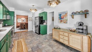 A modern kitchen with green cabinets, a refrigerator, and a coffee maker. - Backyard Pool - Hot Tub - Game Room (Akron)
