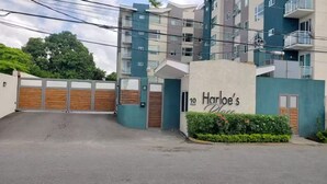 Un edificio de varios pisos con un letrero que dice 'Harlowe's Place' en la entrada.