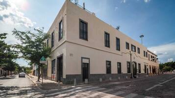 A two-story building with a flat facade, large windows, and a pedestrian crossing.