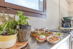 Eine Küchenarbeitsplatte mit verschiedenen Lebensmitteln, einem Fenster und einem Blumentopf.