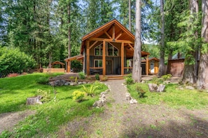 A cabin with a large porch, surrounded by trees and a well-maintained garden. - Mt Hood Cabin, Hot Tub, Fire Pit, Dog-Friendly (Sandy)