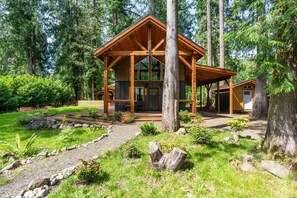Eine Holzhütte mit großen Fenstern und einer überdachten Veranda.