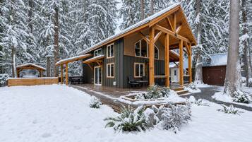 A two-story log cabin with a covered porch and a separate cabin structure.