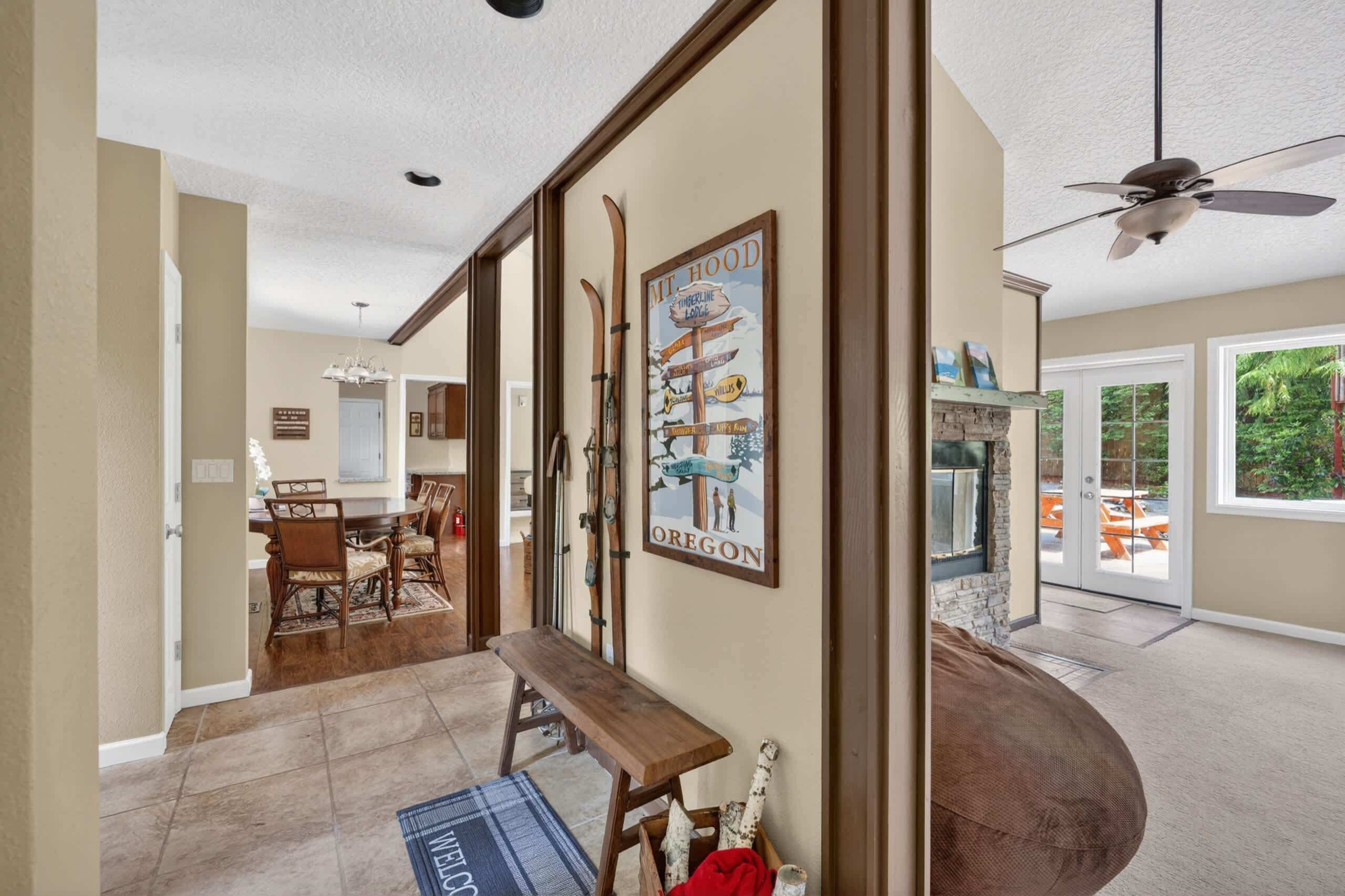 A spacious interior with a dining area, a bench, a ski-themed wall art, and a ceiling fan.