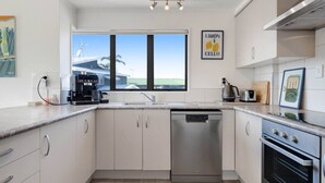 A modern kitchen with a dishwasher, oven, and coffee maker.