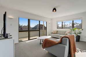 A modern living room with a sofa, a coffee table, and a TV.