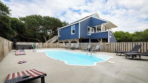 A blue house with a swimming pool, lounge chairs, and a wooden deck. - Coastal Getaway with Pool, Spa, Direct Beach Path! (Southern Shores)