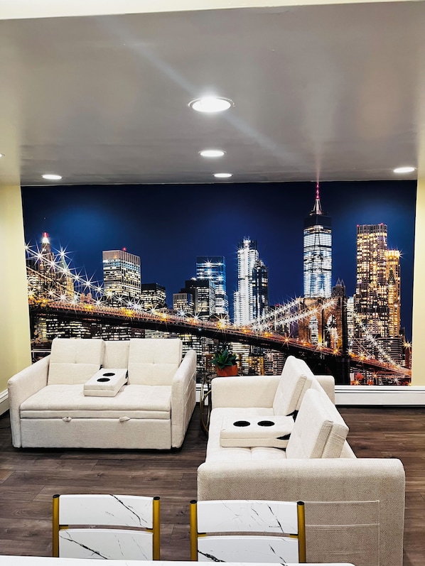 A modern living room with a cityscape mural, two sofas, and a coffee table.