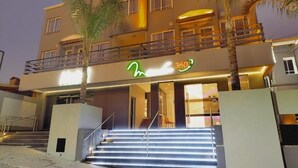 Un hotel de diseño moderno, con una entrada destacada y escalones iluminados y un balcón.