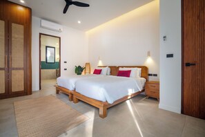Ein Schlafzimmer mit einem hölzernen Bett, Nachttischen, einem Spiegel und einem Deckenventilator.