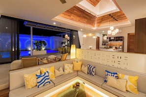 Ein modernes Wohnzimmer mit Sofa, Essbereich und Küche.