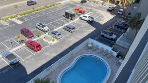 Pool på taget med udsigt over parkeringsplads og bygning.