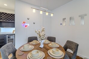 A dining area with a round table set for four, surrounded by grey chairs. - Chic 3-Story Retreat in Houston Heights (Houston)