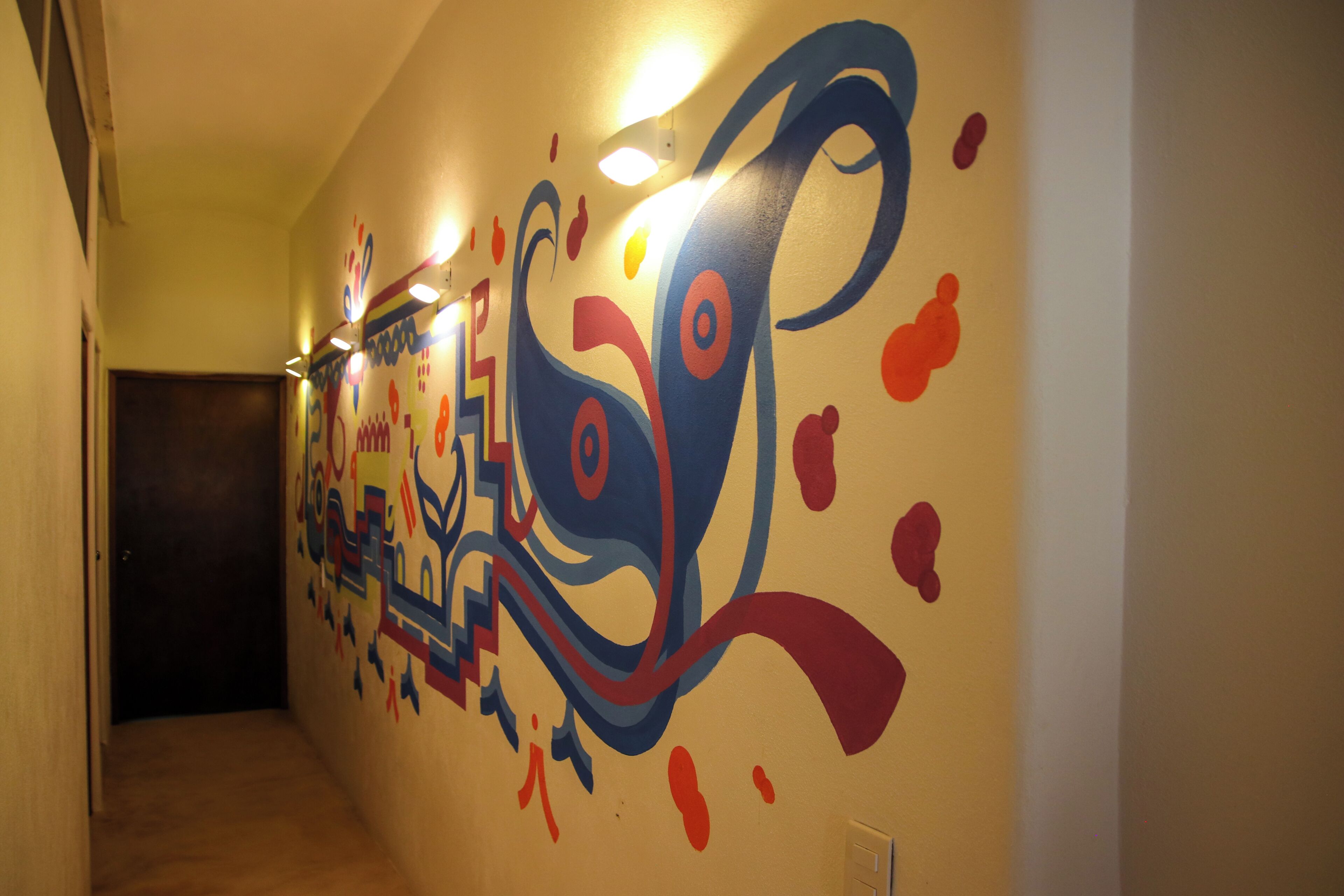 A hallway with a colorful abstract mural on the wall.