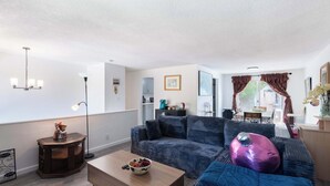 A living room with a sofa, coffee table, and a side table with a lamp. - Seattle Hillside Escape with Decks & Scenic Views (Seattle)